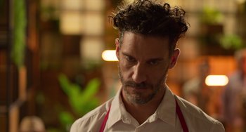 Movie still from “40 Years Young” (2022), directed by Pietro Loprieno – A person wearing a shirt and tie; Close Up shot, Low angle