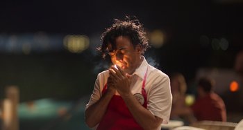 Movie still from “40 Years Young” (2022), directed by Pietro Loprieno – A man in an apron standing in front of a building; Close Up shot, Low angle
