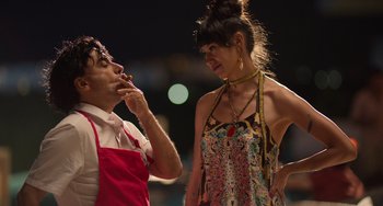 Movie still from “40 Years Young” (2022), directed by Pietro Loprieno – A man and a woman standing next to each other; Medium shot, Low angle