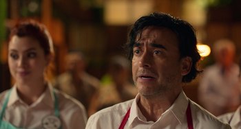 Movie still from “40 Years Young” (2022), directed by Pietro Loprieno – A person wearing a white shirt; Close Up shot, Over the shoulder angle