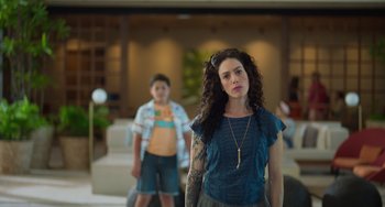 Movie still from “40 Years Young” (2022), directed by Pietro Loprieno – A woman standing in front of a boy in a room; Close Up shot, Low angle