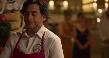 Movie still from “40 Years Young” (2022), directed by Pietro Loprieno – A man in a white shirt and a red apron; Close Up shot, Over the shoulder angle