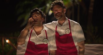 Movie still from “40 Years Young” (2022), directed by Pietro Loprieno – A couple of men standing next to each other; Medium shot, Low angle