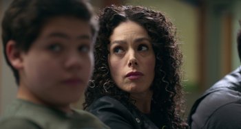 Movie still from “40 Years Young” (2022), directed by Pietro Loprieno – A person with curly brown hair; Close Up shot, Over the shoulder angle