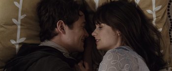 Movie still from “500 Days of Summer” (2009), directed by Marc Webb – A man and a woman laying on a bed together; Close Up shot, Overhead angle