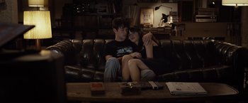 Movie still from “500 Days of Summer” (2009), directed by Marc Webb – A man and a woman sitting on top of a brown couch; Medium shot, High angle