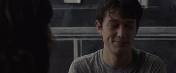 Movie still from “500 Days of Summer” (2009), directed by Marc Webb – A young man smiling while sitting in front of another man; Close Up shot, Over the shoulder angle