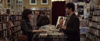 Movie still from “500 Days of Summer” (2009), directed by Marc Webb – A man and a woman looking at records in a record store; Medium shot, Over the shoulder angle