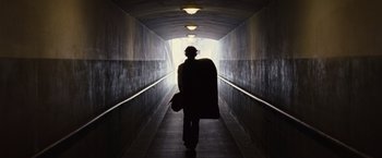 Movie still from “500 Days of Summer” (2009), directed by Marc Webb – A person walking down a tunnel with a bag; Wide shot, Low angle