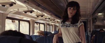 Movie still from “500 Days of Summer” (2009), directed by Marc Webb – A woman standing on a train looking at the camera; Medium shot, Over the shoulder angle