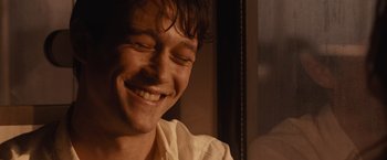 Movie still from “500 Days of Summer” (2009), directed by Marc Webb – A person smiling with his eyes closed; Close Up shot, Over the shoulder angle