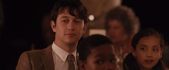 Movie still from “500 Days of Summer” (2009), directed by Marc Webb – A man in a suit and tie looking at the camera; Close Up shot, Over the shoulder angle