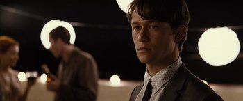 Movie still from “500 Days of Summer” (2009), directed by Marc Webb – A man in a suit and tie looking at the camera; Close Up shot, Over the shoulder angle