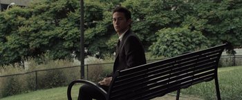 Movie still from “500 Days of Summer” (2009), directed by Marc Webb – A man sitting on a park bench in a suit; Medium shot, Over the shoulder angle