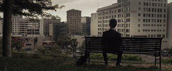 Movie still from “500 Days of Summer” (2009), directed by Marc Webb – A man sitting on top of a park bench looking out over a city; Extreme Wide shot, High angle