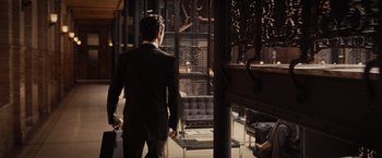 Movie still from “500 Days of Summer” (2009), directed by Marc Webb – A man in a black suit is walking through a room; Wide shot, Over the shoulder angle