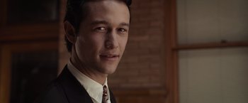 Movie still from “500 Days of Summer” (2009), directed by Marc Webb – A man wearing a suit and tie smiling for the camera; Close Up shot, Over the shoulder angle