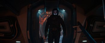 Movie still from “65” (2023), directed by Bryan Woods – A man with a gun standing in a dark tunnel; Medium shot, Low angle