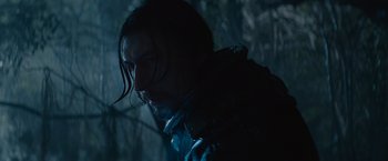 Movie still from “65” (2023), directed by Bryan Woods – A person with long black hair; Close Up shot, Low angle