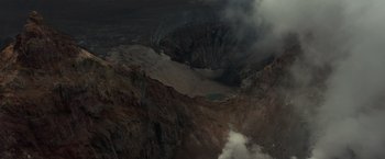 Movie still from “65” (2023), directed by Bryan Woods – A view of a crater from a helicopter; Extreme Wide shot, Overhead angle