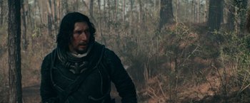 Movie still from “65” (2023), directed by Bryan Woods – A man standing in the woods; Medium shot, Over the shoulder angle
