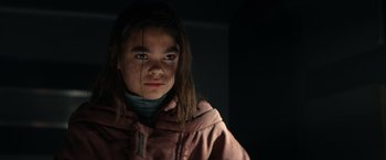 Movie still from “65” (2023), directed by Bryan Woods – A young girl in a pink jacket looking at the camera; Close Up shot, Low angle