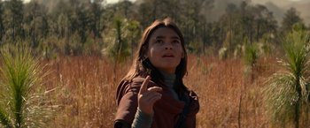 Movie still from “65” (2023), directed by Bryan Woods – A young girl is standing in a field; Close Up shot, Low angle