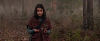 Movie still from “65” (2023), directed by Bryan Woods – A young girl holding a plant in her hands; Medium shot, Over the shoulder angle
