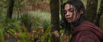 Movie still from “65” (2023), directed by Bryan Woods – A young girl with wet hair standing in a forest; Close Up shot, Over the shoulder angle