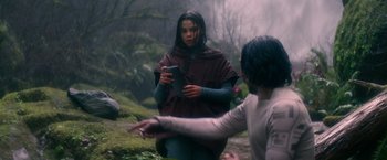 Movie still from “65” (2023), directed by Bryan Woods – Two people in the woods looking at something on a tablet; Medium shot, Over the shoulder angle