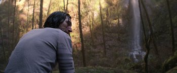 Movie still from “65” (2023), directed by Bryan Woods – An image of a man in the woods; Medium shot, Over the shoulder angle
