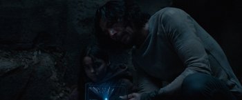 Movie still from “65” (2023), directed by Bryan Woods – A man and a woman looking at a tablet; Medium shot, High angle