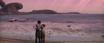 Movie still from “65” (2023), directed by Bryan Woods – Two people standing on the beach looking out at the ocean; Wide shot, Low angle