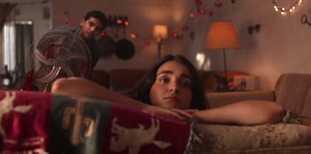 A woman sitting on top of a couch next to a man