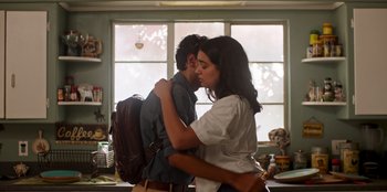 A man and a woman kissing in a kitchen