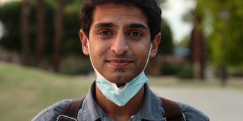 A man wearing a face mask and a backpack