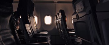 Movie still from “752 Is Not a Number” (2022), directed by Babak Payami – A row of seats on an airplane with a window in the background; Wide shot, High angle
