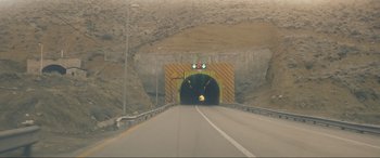 Movie still from “752 Is Not a Number” (2022), directed by Babak Payami – An empty road with a tunnel on the side of it; Extreme Wide shot, Low angle