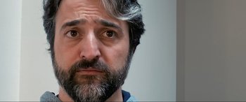 Movie still from “752 Is Not a Number” (2022), directed by Babak Payami – A person with a beard; Close Up shot, Over the shoulder angle