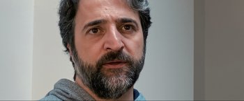 Movie still from “752 Is Not a Number” (2022), directed by Babak Payami – A person with a beard; Close Up shot, Over the shoulder angle