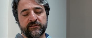 Movie still from “752 Is Not a Number” (2022), directed by Babak Payami – A person with his eyes closed; Close Up shot, Low angle