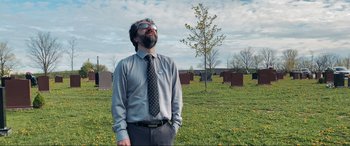 Movie still from “752 Is Not a Number” (2022), directed by Babak Payami – A man standing in the grass with his hands in his pockets; Medium shot, Low angle