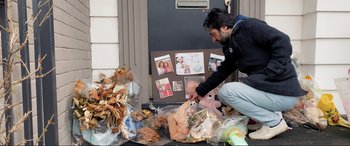 Movie still from “752 Is Not a Number” (2022), directed by Babak Payami – A man kneeling down next to a pile of garbage; Wide shot, High angle