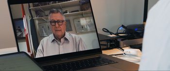 Movie still from “752 Is Not a Number” (2022), directed by Babak Payami – An older man is on a video call on a computer; Close Up shot, Over the shoulder angle