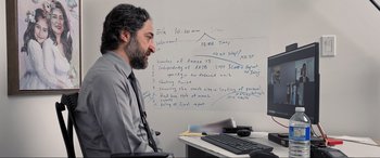 Movie still from “752 Is Not a Number” (2022), directed by Babak Payami – A man sitting in front of a computer monitor; Medium shot, Over the shoulder angle