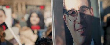 Movie still from “752 Is Not a Number” (2022), directed by Babak Payami – A person's face on a poster; Close Up shot, High angle