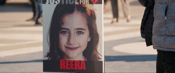 Movie still from “752 Is Not a Number” (2022), directed by Babak Payami – A poster with a picture of reera on it; Medium shot, Overhead angle