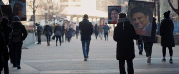 Movie still from “752 Is Not a Number” (2022), directed by Babak Payami – A group of people walking down a street holding signs; Medium shot, High angle