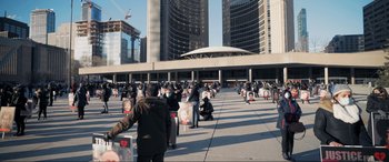 Movie still from “752 Is Not a Number” (2022), directed by Babak Payami – A group of people standing in front of a large building; Extreme Wide shot, High angle