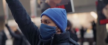 Movie still from “752 Is Not a Number” (2022), directed by Babak Payami – A man wearing a blue hat and a blue mask; Close Up shot, Low angle